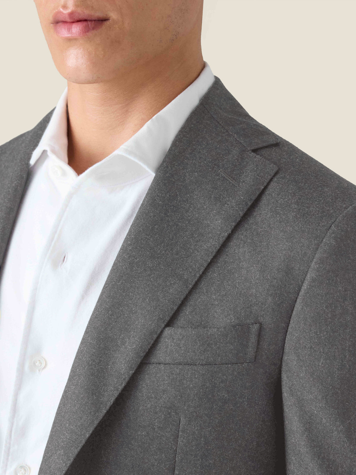 Close-up of a model wearing the Luca Faloni charcoal grey wool suit, focusing on the jacket's lapel and textured fabric.