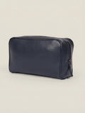 Three-quarter view of the Ink Blue leather wash bag in full-grain calfskin, set against a neutral background.