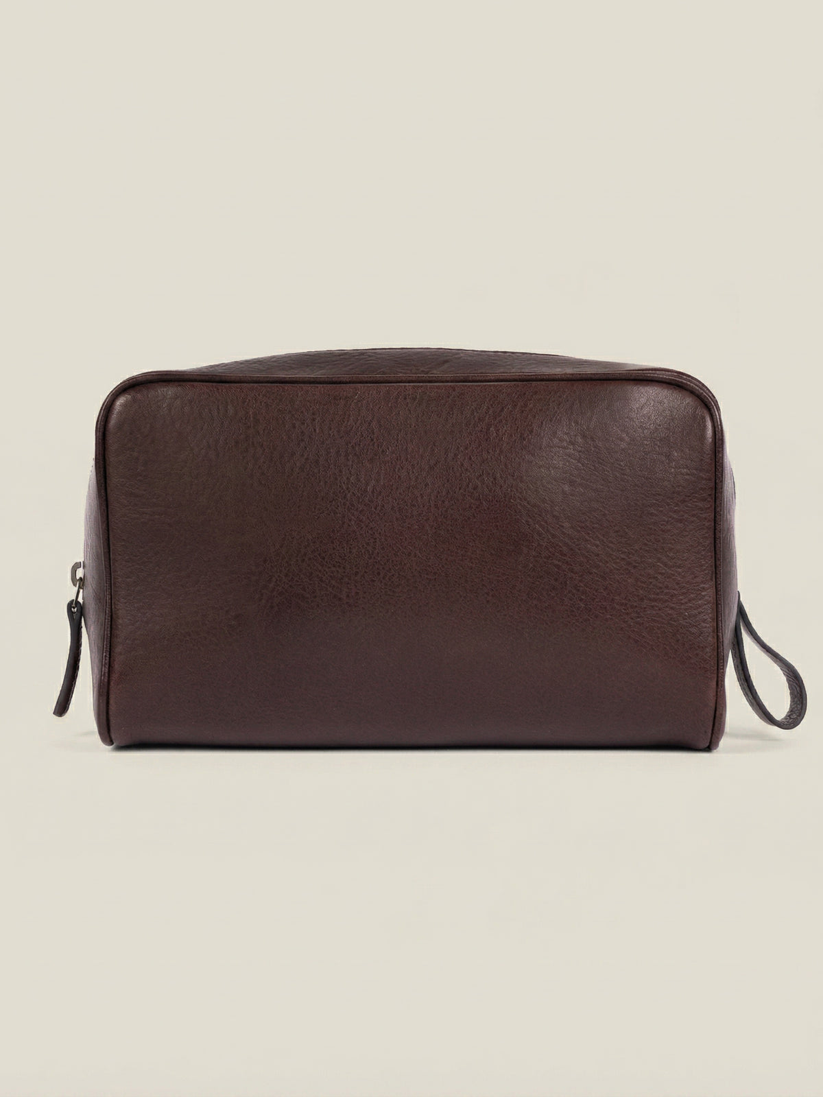 Front view of the chocolate brown leather wash bag in full-grain calfskin, featured on a neutral background.