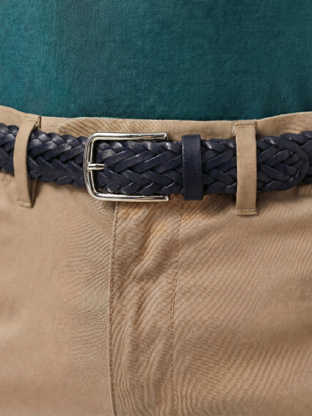 Woven midnight blue leather belt with a silver-toned metal buckle, worn with tan chinos and a teal shirt.