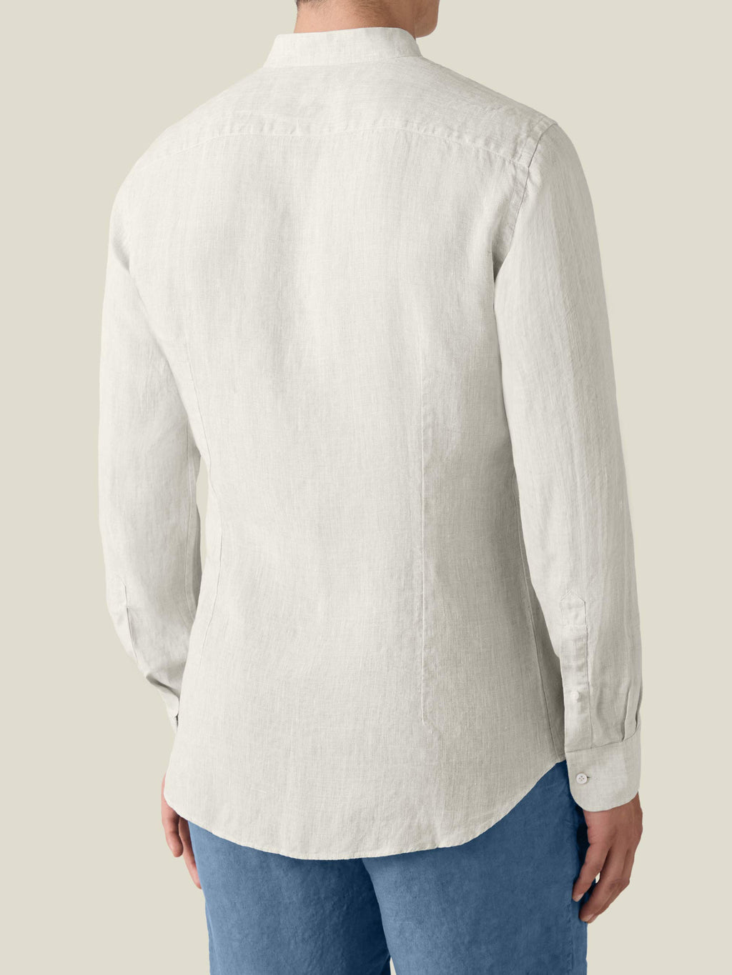 Back view of the sand Versilia Linen Shirt in breathable Italian linen, worn by a man with blue trousers.