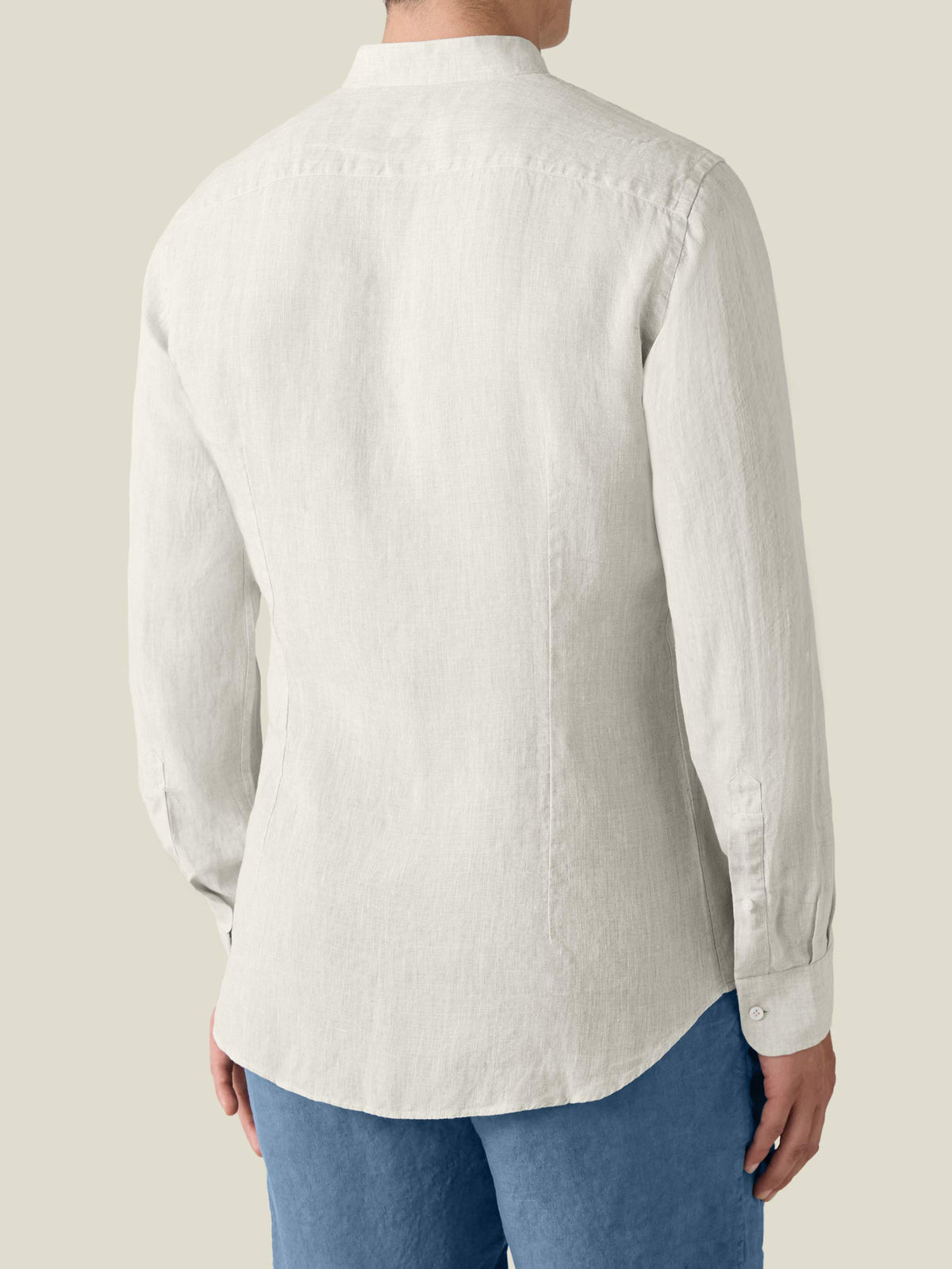Back view of the sand Versilia Linen Shirt in breathable Italian linen, worn by a man with blue trousers.