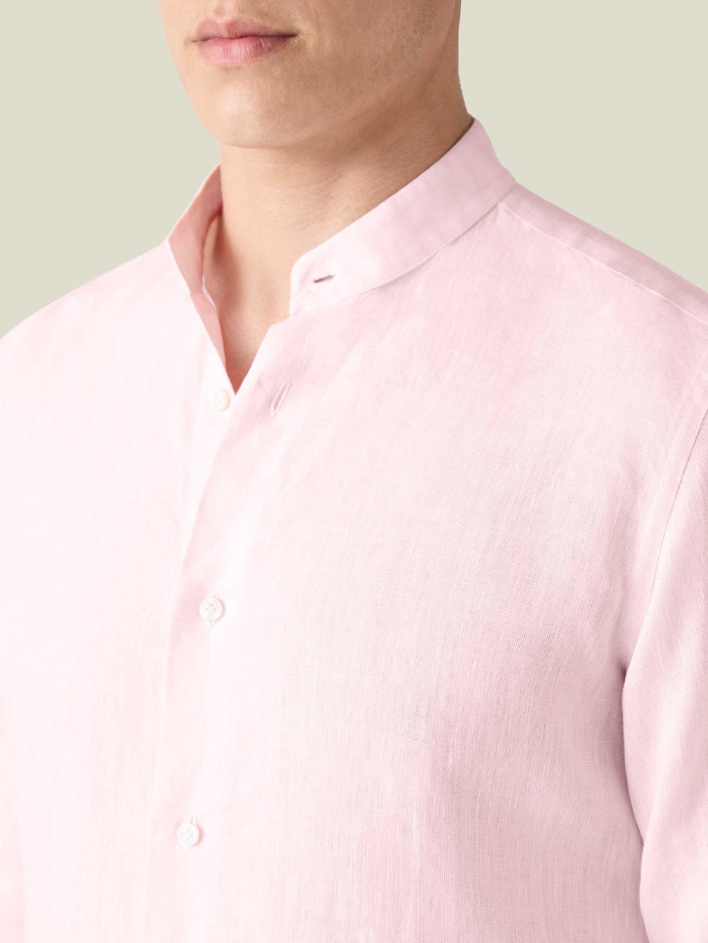 Close-up of the light pink Versilia Linen Shirt with a band collar and mother of pearl buttons.