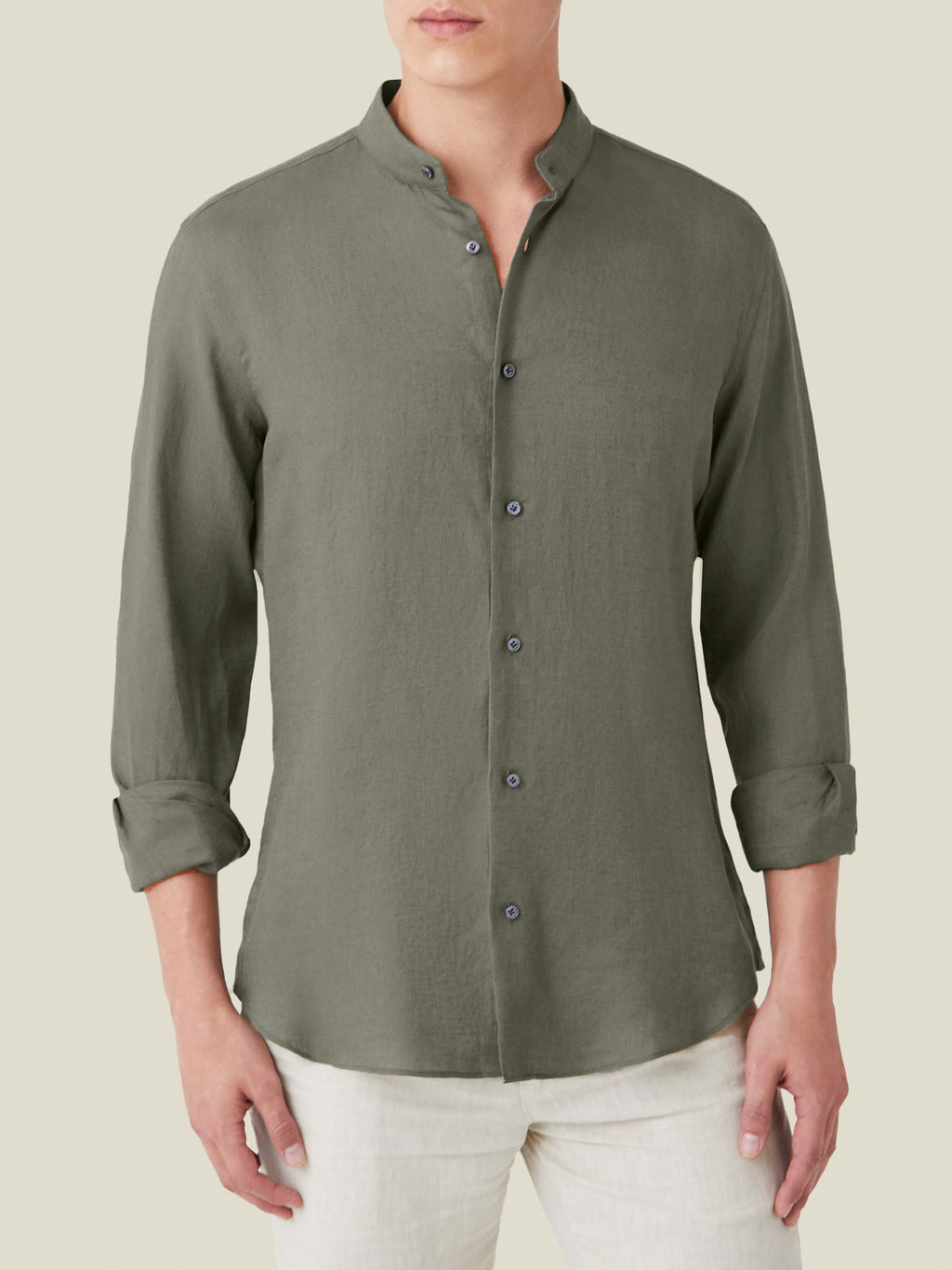 Khaki green Versilia linen shirt with a band collar and rolled sleeves, worn by a model with light trousers.