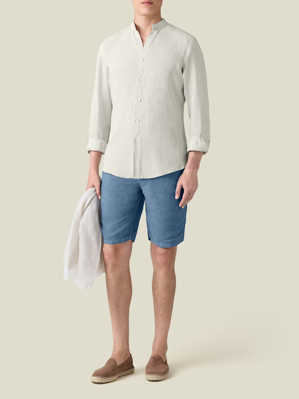 Front view of the sand Versilia Linen Shirt with a band collar, worn by a model with blue shorts and loafers.