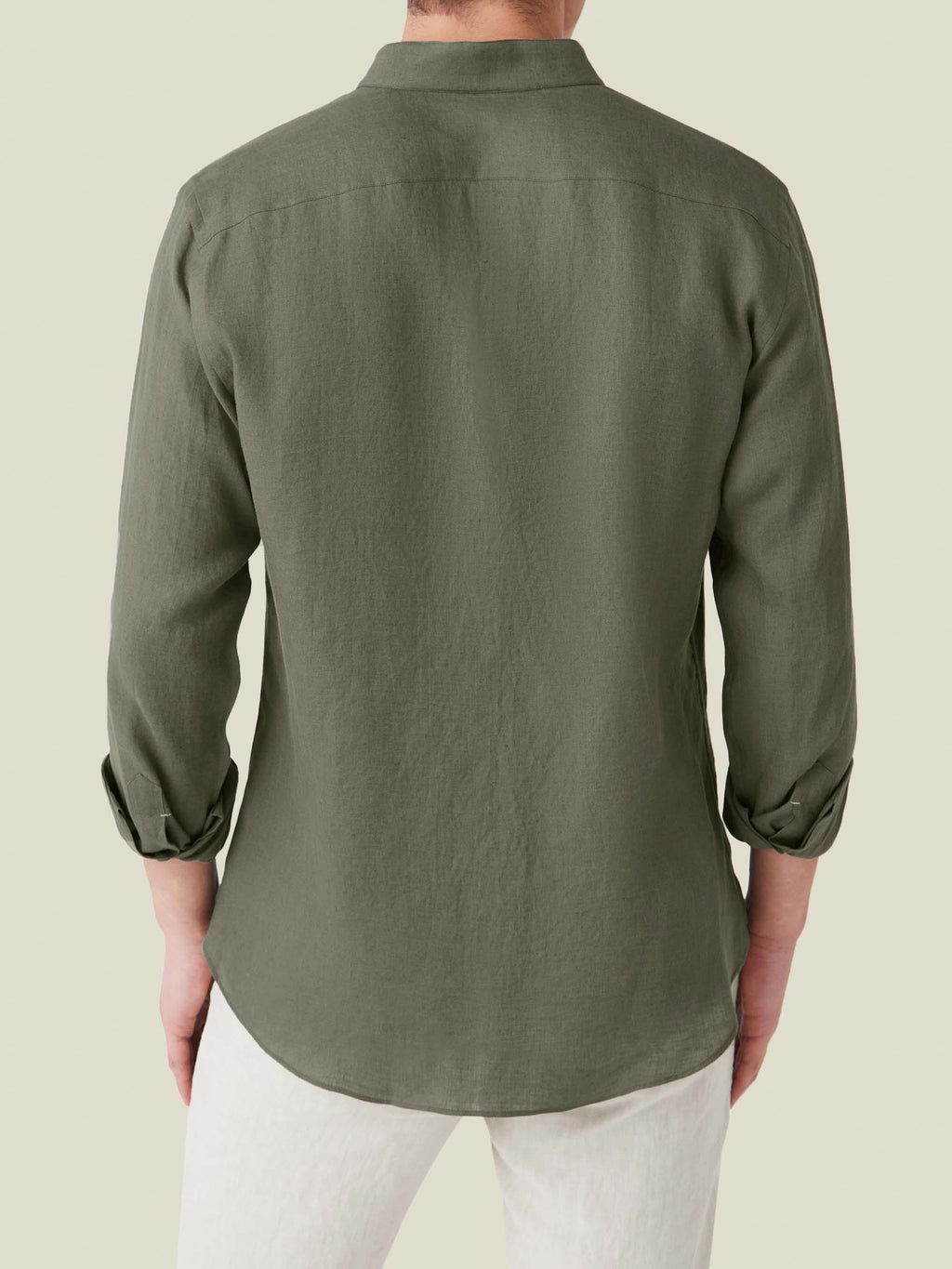 Back view of the khaki green Versilia Linen Shirt with rolled sleeves, worn by a model.