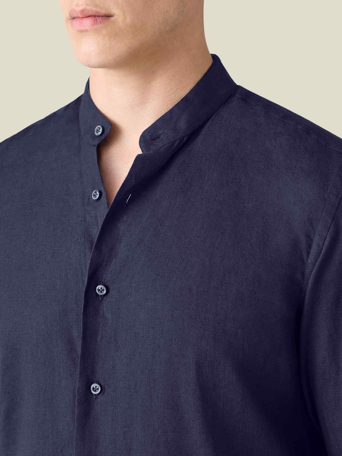 Close-up of the midnight blue Versilia Linen Shirt featuring a band collar and mother-of-pearl buttons.
