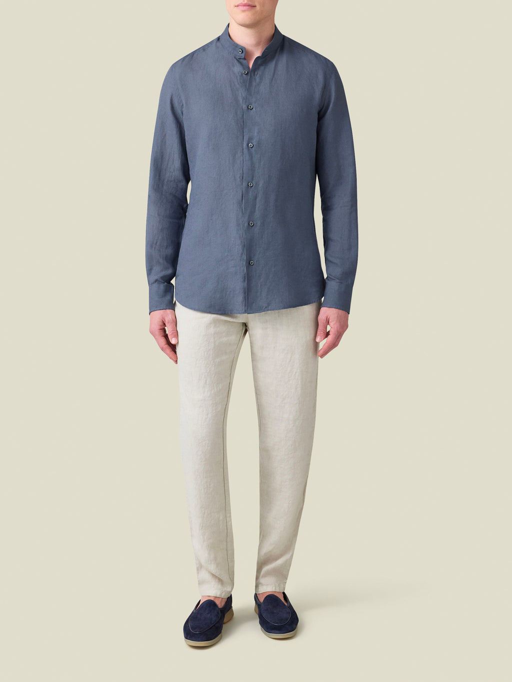 Front view of the Payne's Grey Versilia Linen Shirt with a band collar, worn by a model with light linen trousers.