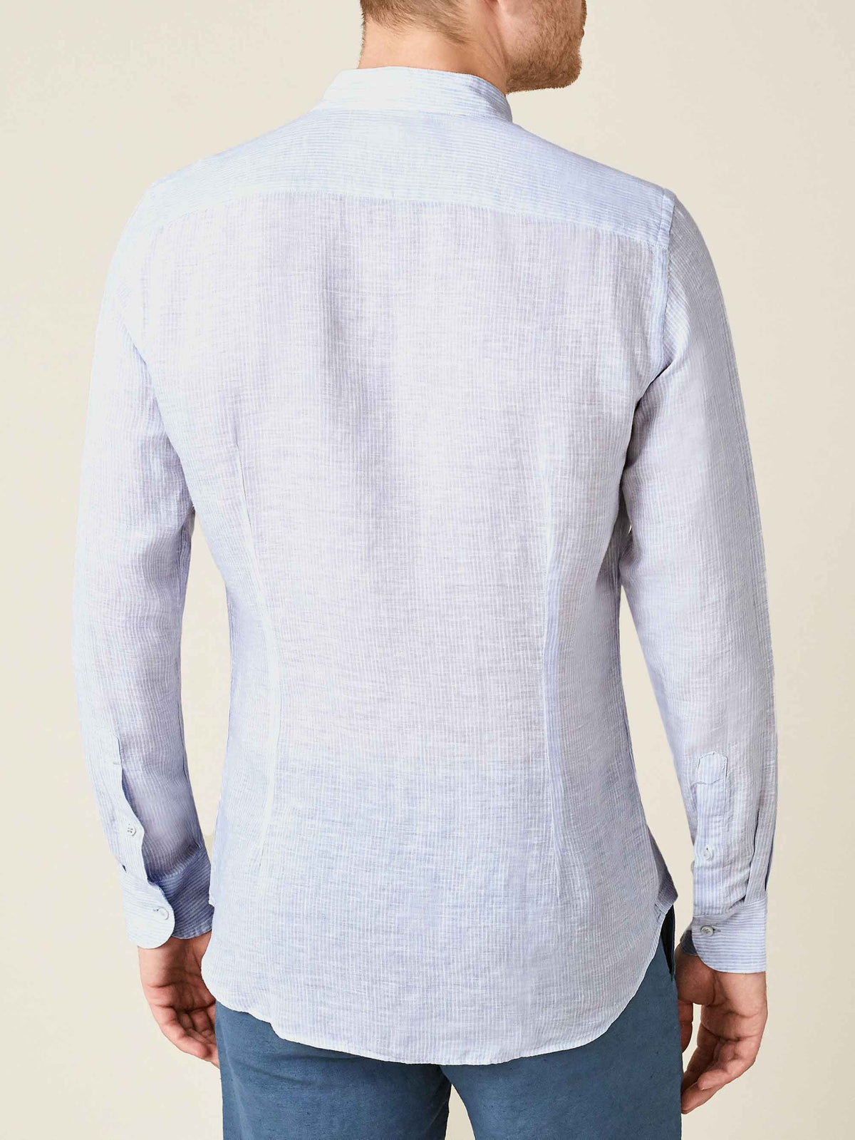 Back view of a man wearing the striped sky blue Versilia Linen Shirt in breathable Italian linen.