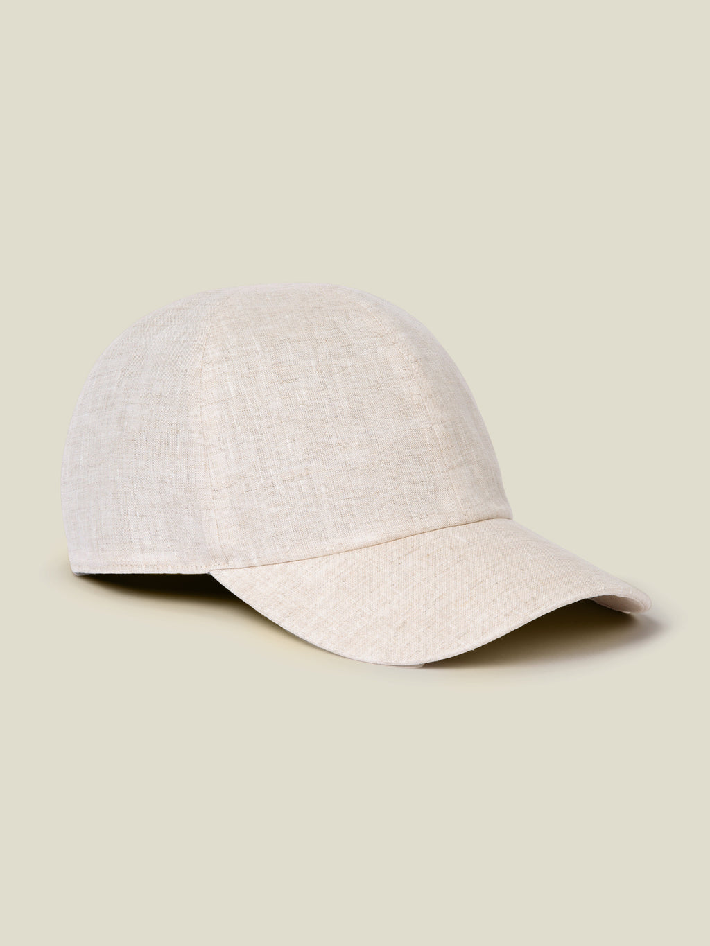 Side view of the Junior Linen Baseball Cap in sand, showcasing its classic shape and the fine texture of the Italian linen.