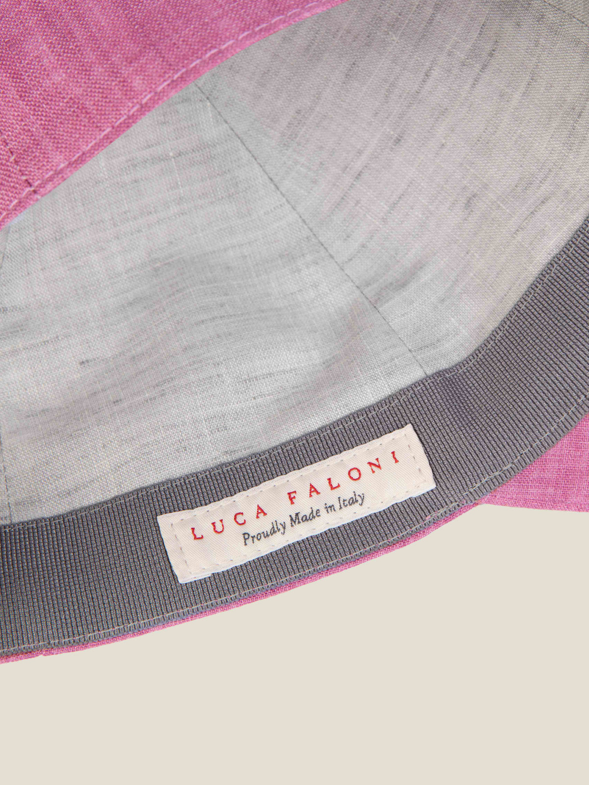 Close-up of the Dusty Pink Linen Baseball Cap's interior, showing the contrast lining and 'Luca Faloni, Made in Italy' label.