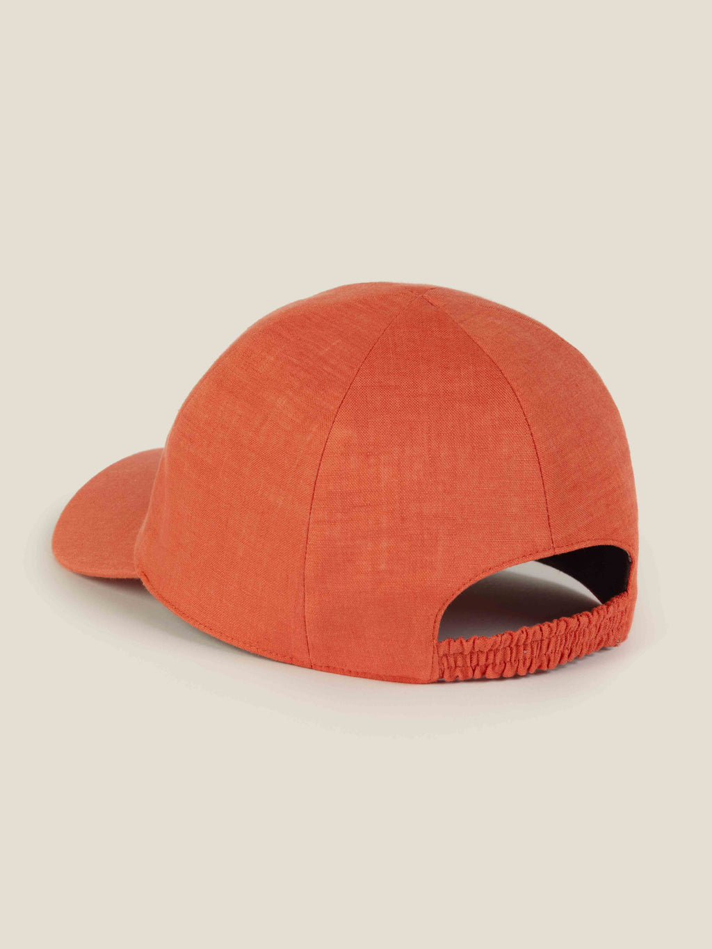 Back of Luca Faloni's coral linen baseball cap, showing the elasticated strap.