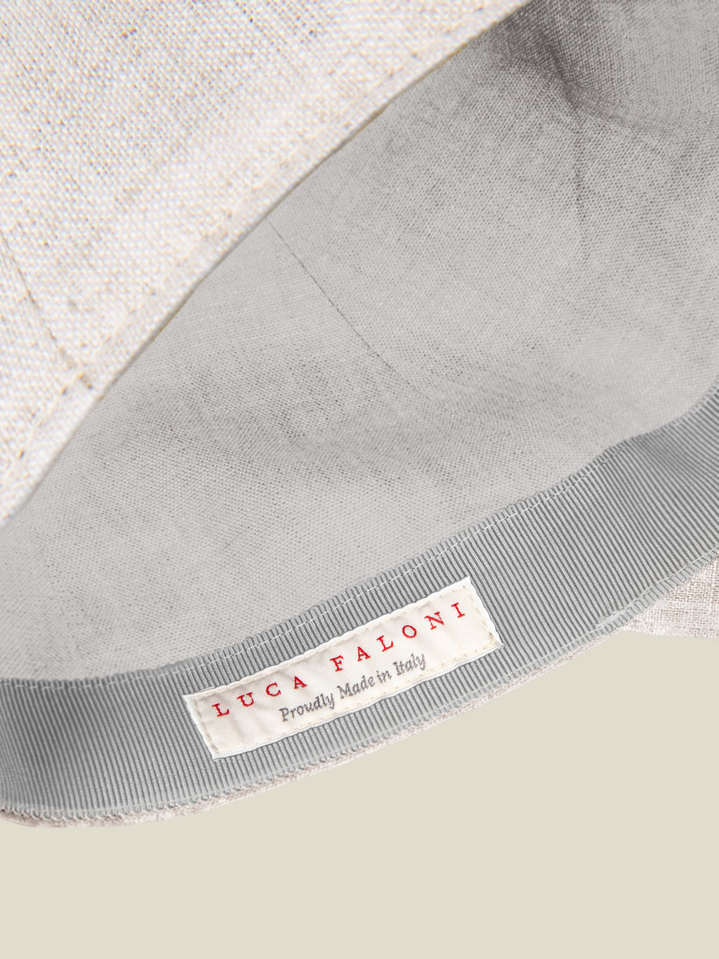 Detail of the Luca Faloni Sand Linen Baseball Cap, highlighting the inner lining and 'Proudly Made in Italy' brand label.