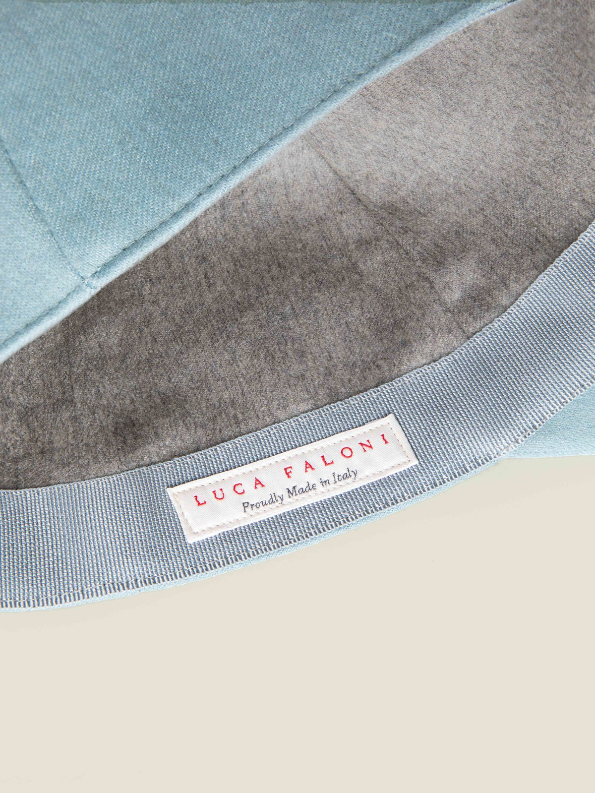 Close-up of the 'Made in Italy' label inside the French Blue Cashmere Baseball Cap, showing the soft brushed cashmere lining.