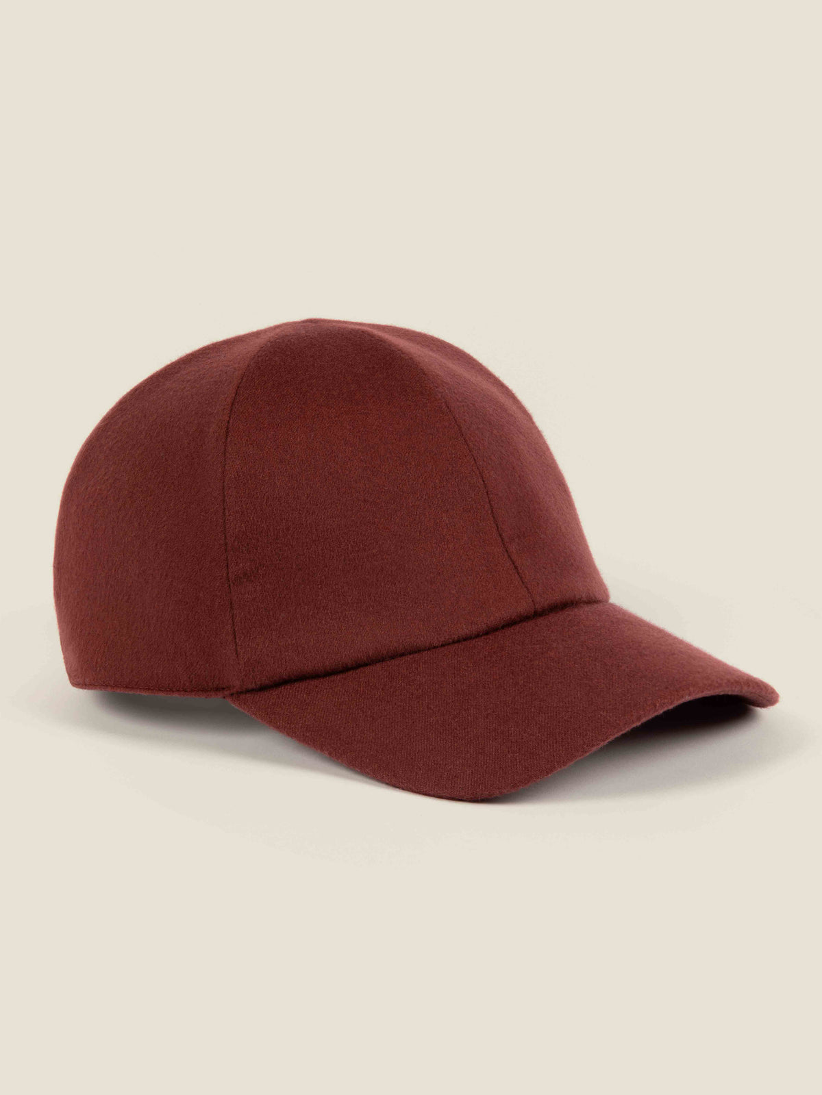Side view of the Luca Faloni Cashmere Baseball Cap in a rich rust red, against a plain background.