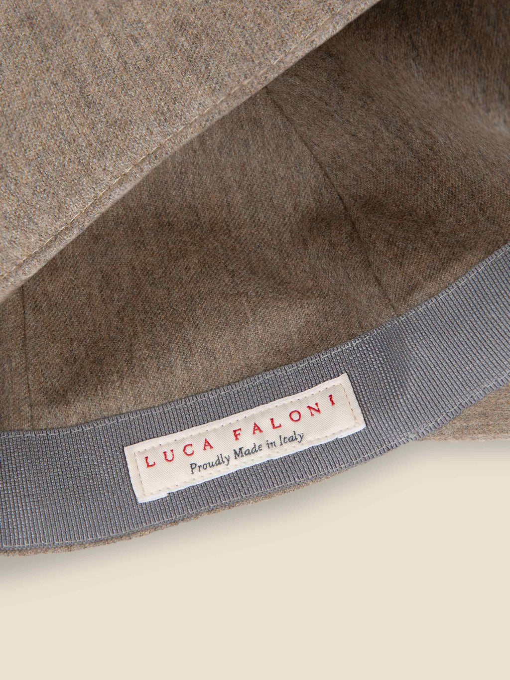Interior detail of the Luca Faloni oatmeal cashmere baseball cap, showing the 'Made in Italy' label and fabric texture.
