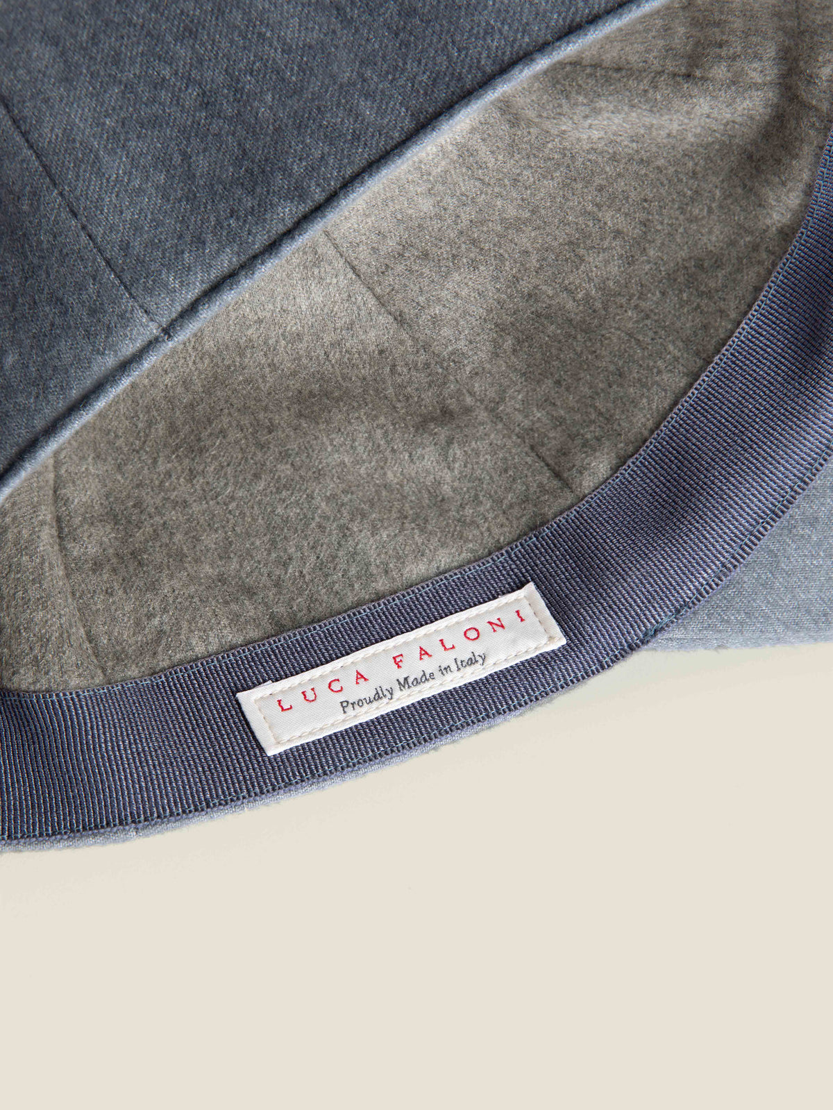 Close-up of the Luca Faloni 'Made in Italy' label inside the Whale Blue Cashmere Baseball Cap, showing the soft lining.