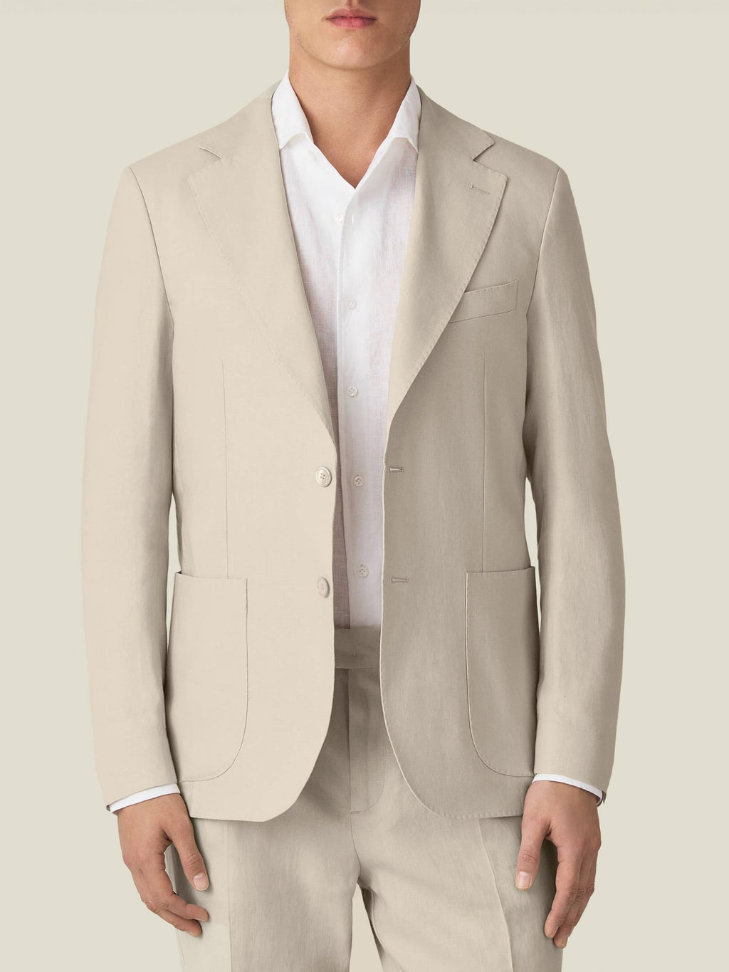 Front view of a man wearing the Luca Faloni Sand Linen Blazer, styled with a white shirt and matching linen trousers.