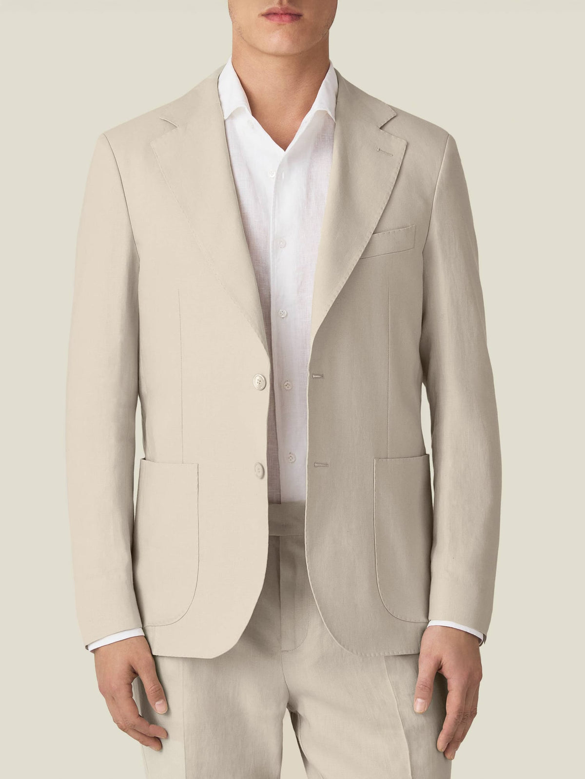 Front view of a man wearing the Luca Faloni Sand Linen Blazer, styled with a white shirt and matching linen trousers.