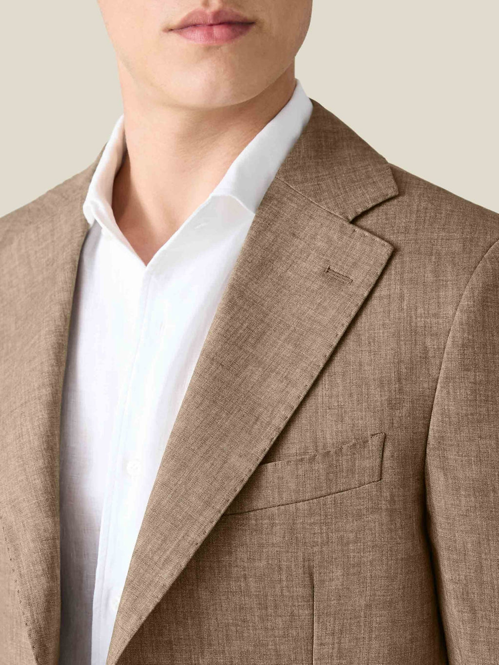 Close-up of a model wearing the Luca Faloni Hazelnut Brown Linen Blazer, showing the notch lapel and fine linen texture.