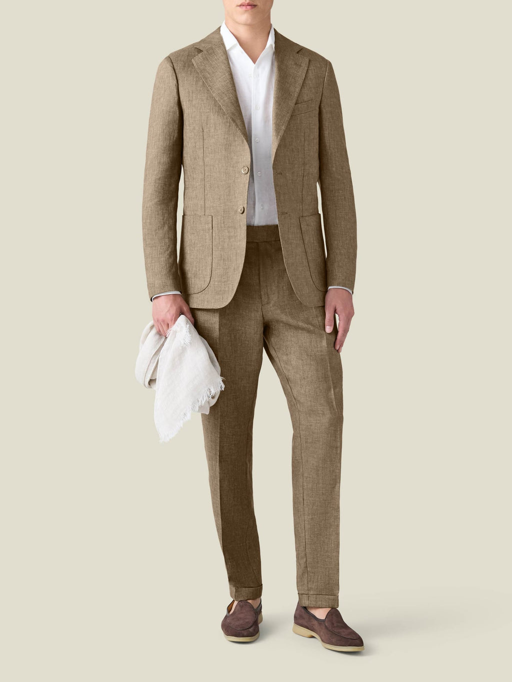 A model wears the Luca Faloni Hazelnut Brown Linen Suit, styled with a white shirt and brown loafers.