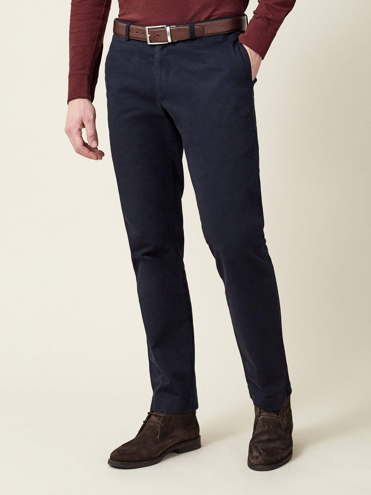 A styled shot of the Luca Faloni Reversible Calf Leather Belt, shown in brown with navy chinos and a burgundy sweater.