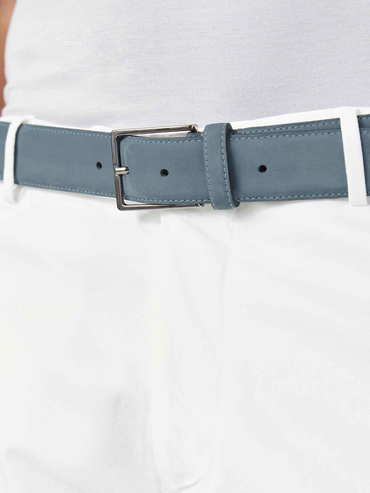 Close-up of the Luca Faloni steel blue nubuck belt, styled with white trousers and a white top.