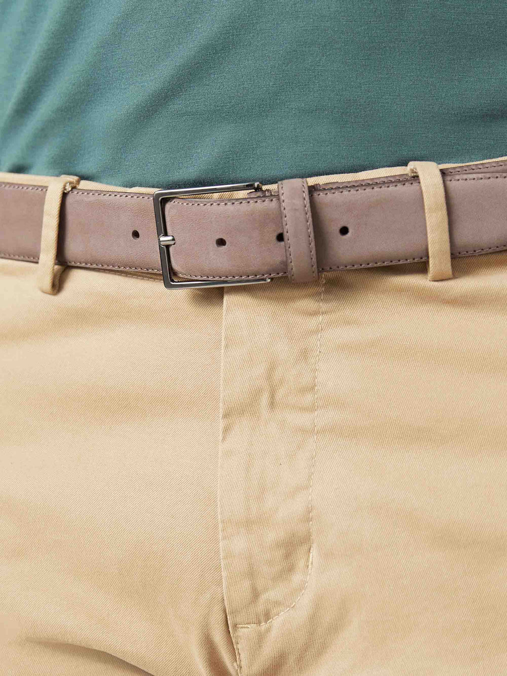 Close-up of the Luca Faloni Hazelnut Brown Nubuck Belt, styled with tan chinos and a green polo shirt.