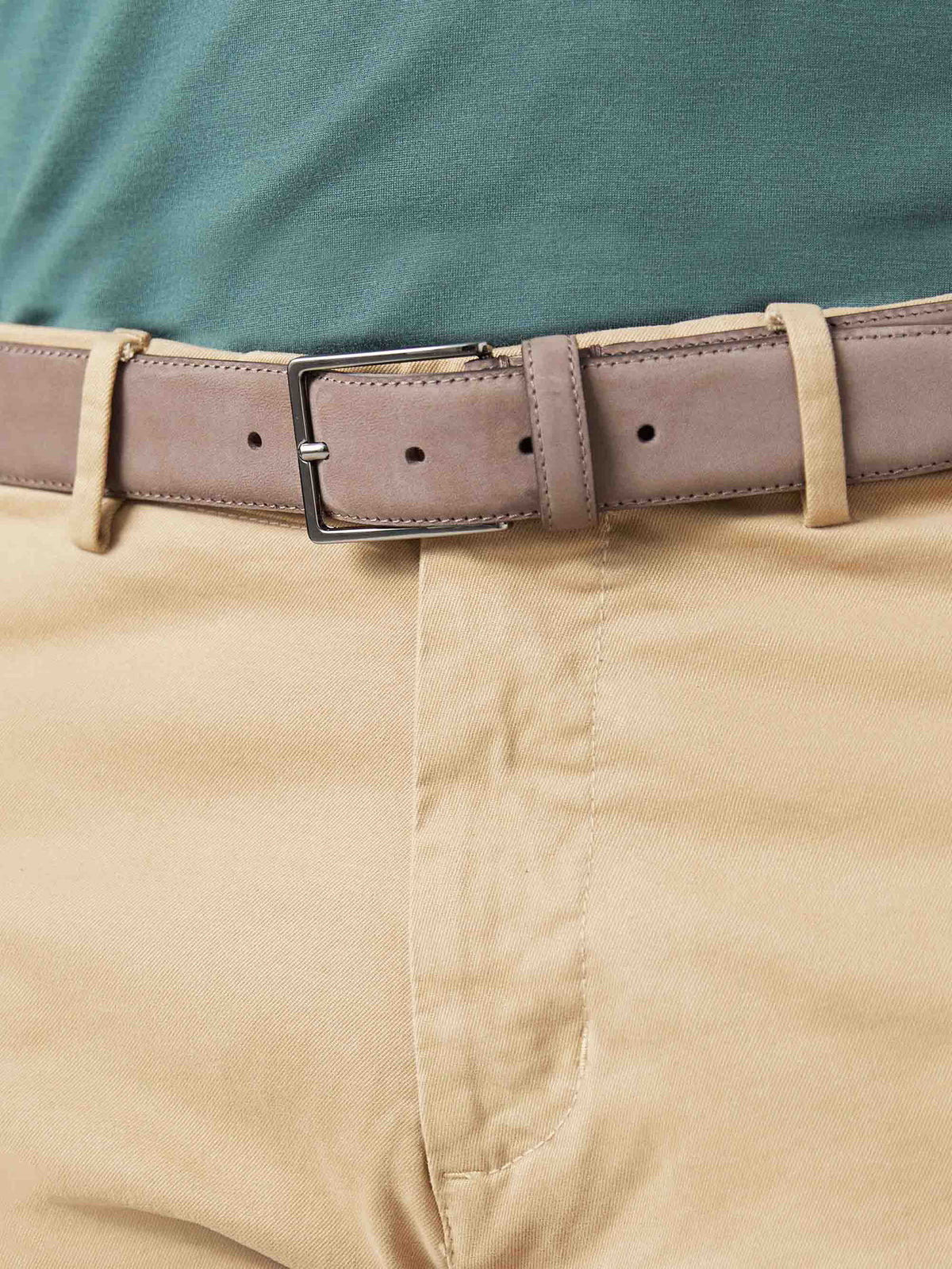 Close-up of the Luca Faloni Hazelnut Brown Nubuck Belt, styled with tan chinos and a green polo shirt.