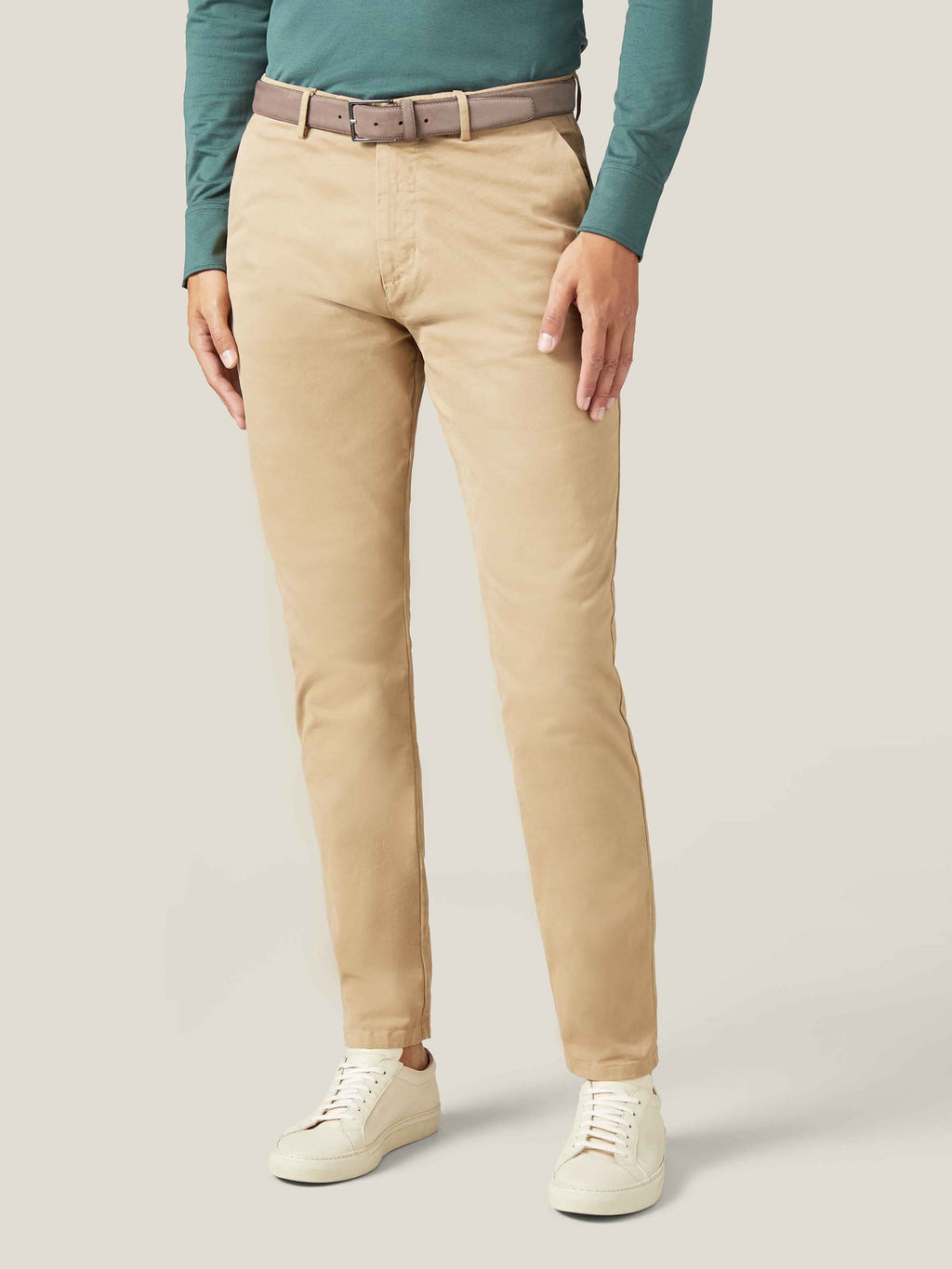 Model wears the Luca Faloni Hazelnut Brown Nubuck Belt with sand chinos and a green long-sleeve top.