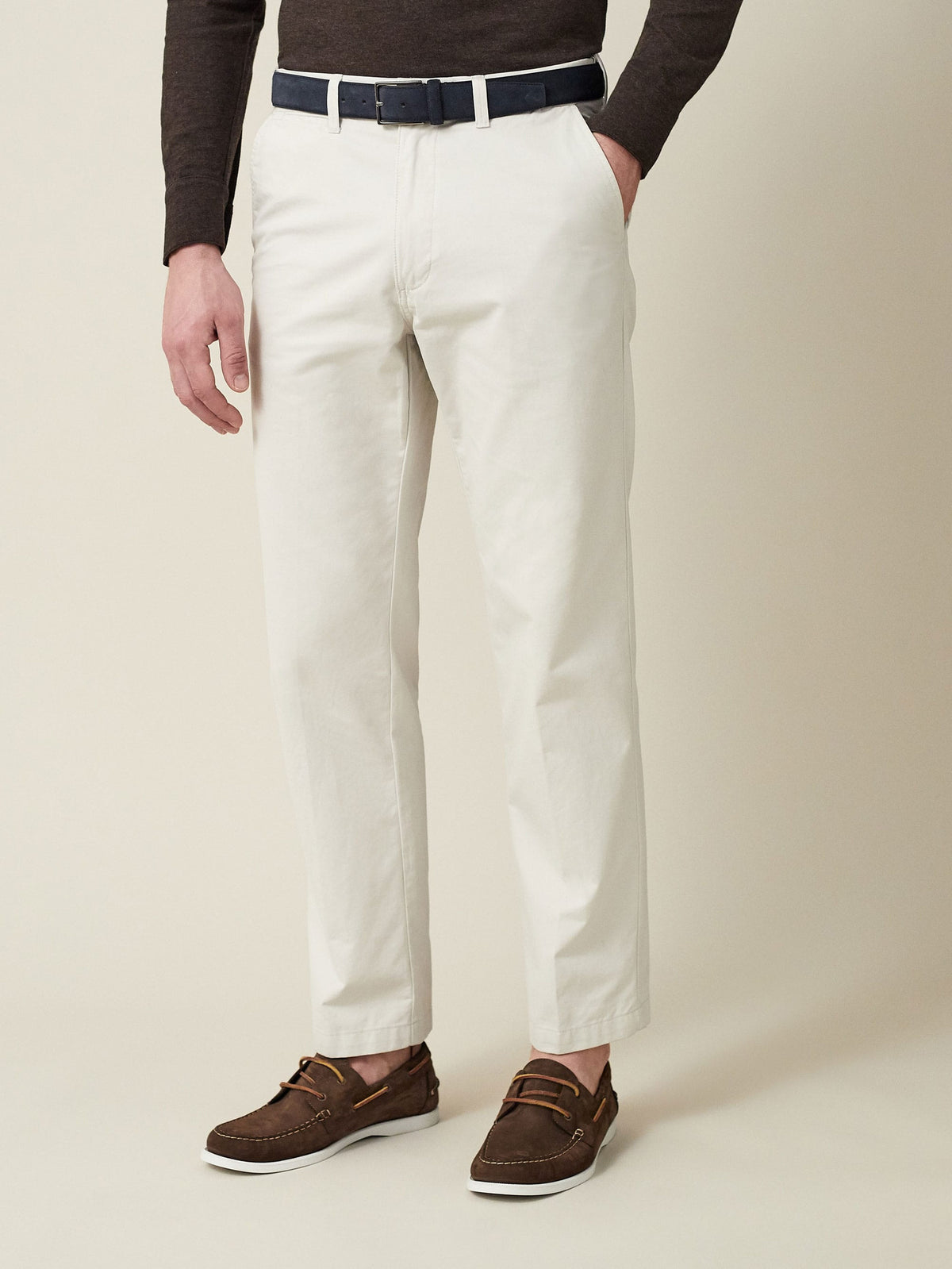 Model wearing the Luca Faloni Classic Suede Belt in navy blue, styled with off-white chinos and a dark brown sweater.
