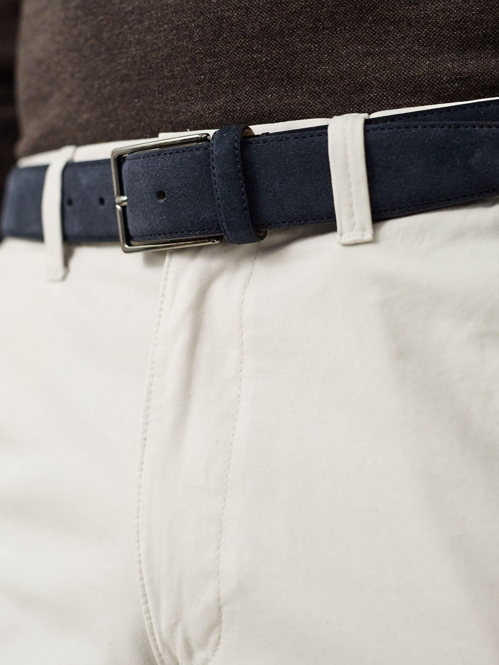 Close-up of the Luca Faloni Classic Suede Belt in navy blue, styled with off-white trousers and a dark top.