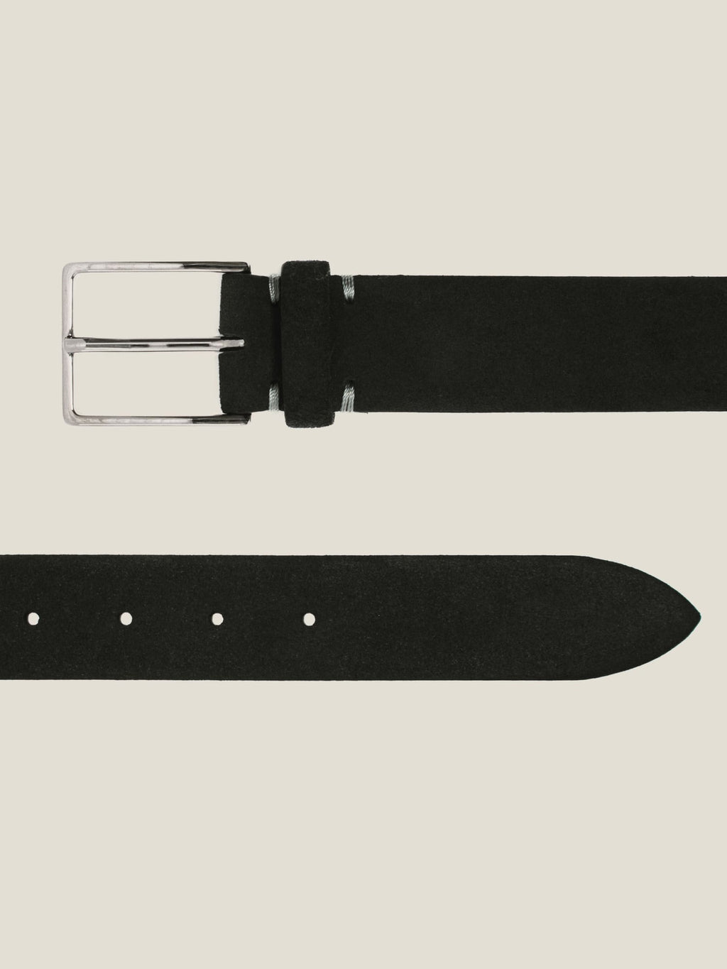 Flat lay detail of the black Classic Suede Belt, showcasing its silver-tone buckle and the pointed tip of the strap.