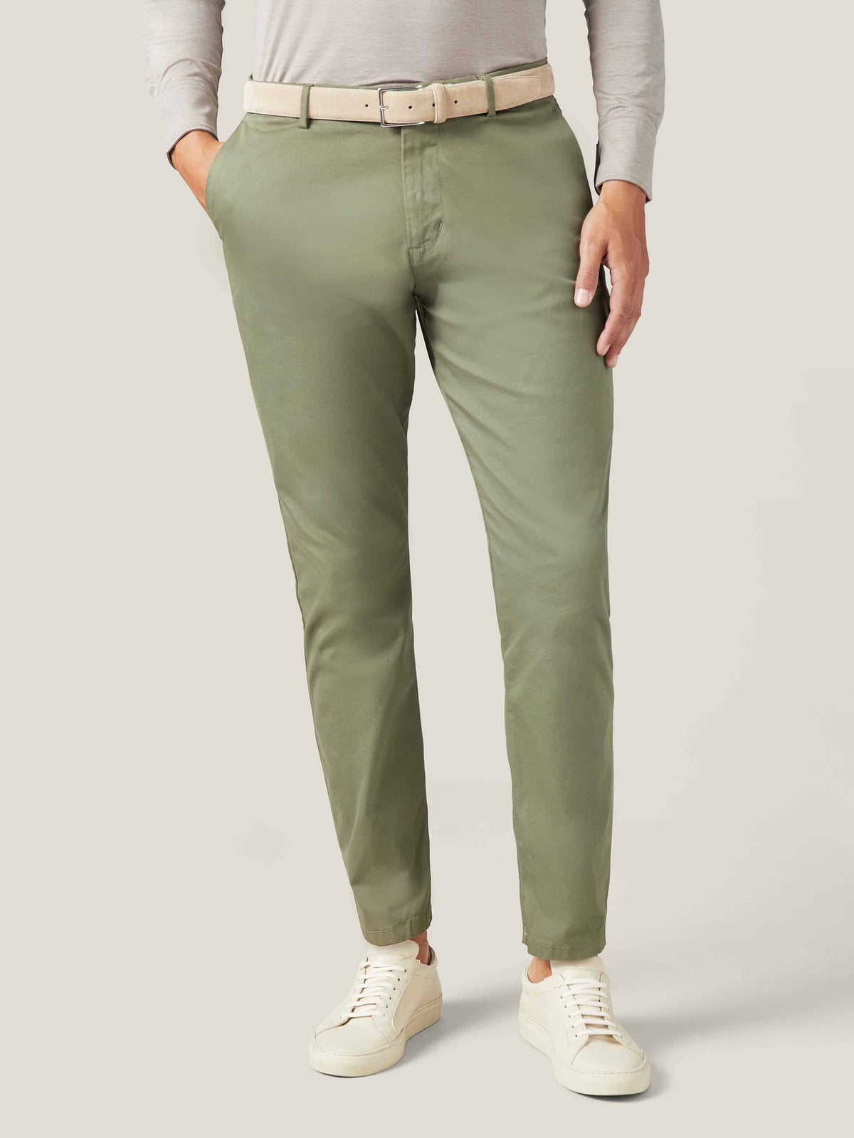 A model wears the Luca Faloni Classic Suede Belt in Sand, paired with olive green chinos and a light grey long-sleeve shirt.