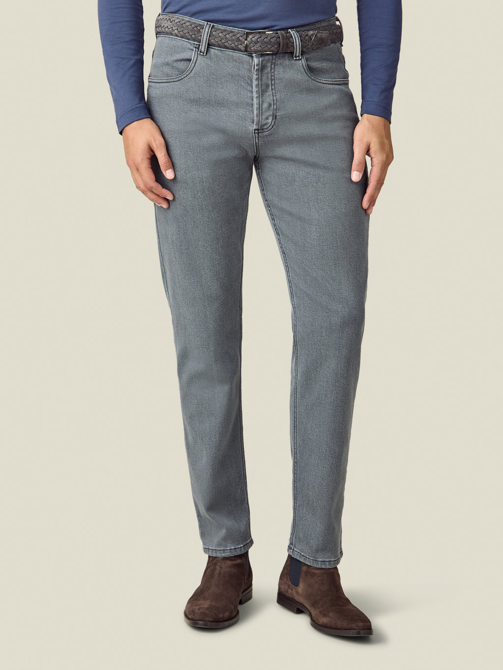 Model wearing the Luca Faloni Woven Belt in charcoal grey, paired with grey jeans and a navy long-sleeved top.