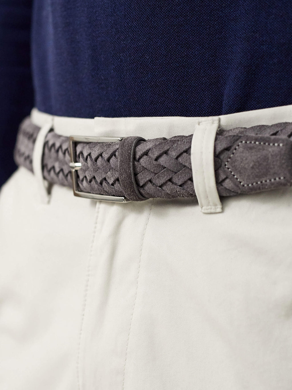 A close-up shot of a model wearing the Luca Faloni Grey Woven Suede Belt with cream trousers and a navy top.