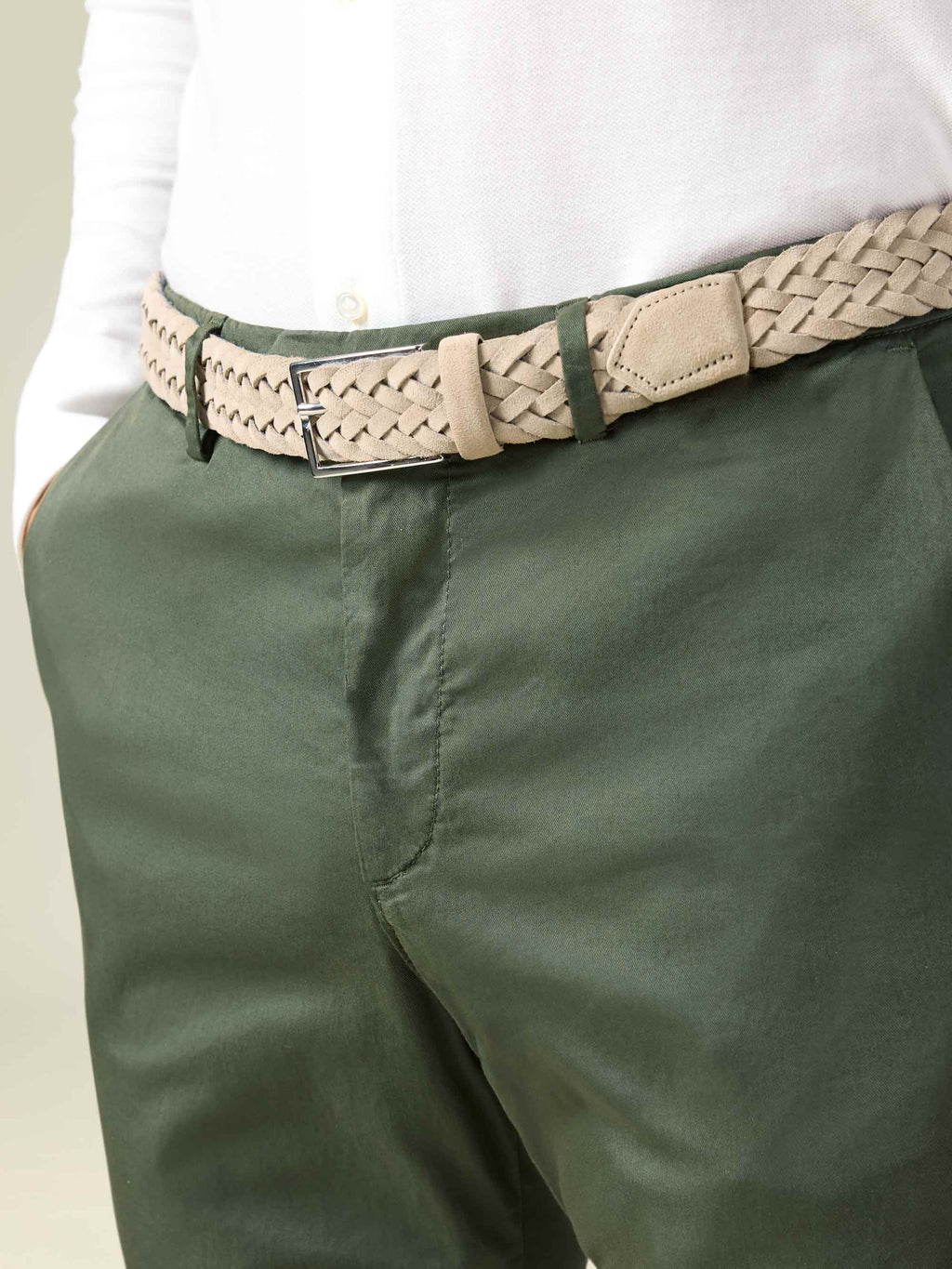 A close-up of a model wearing the Luca Faloni sand woven suede belt with olive green chinos and a white shirt.