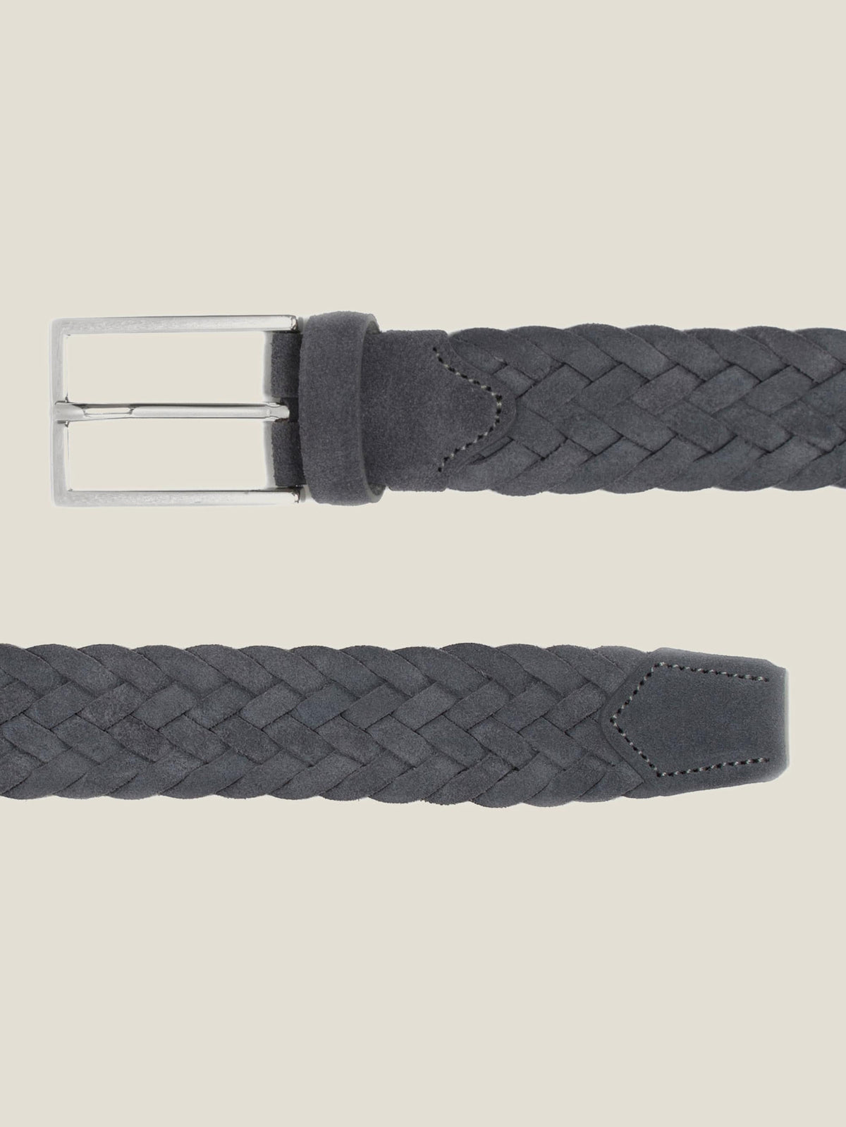 Flat lay detail of the grey woven suede belt, showing the silver buckle and the tip of the belt against a light background.