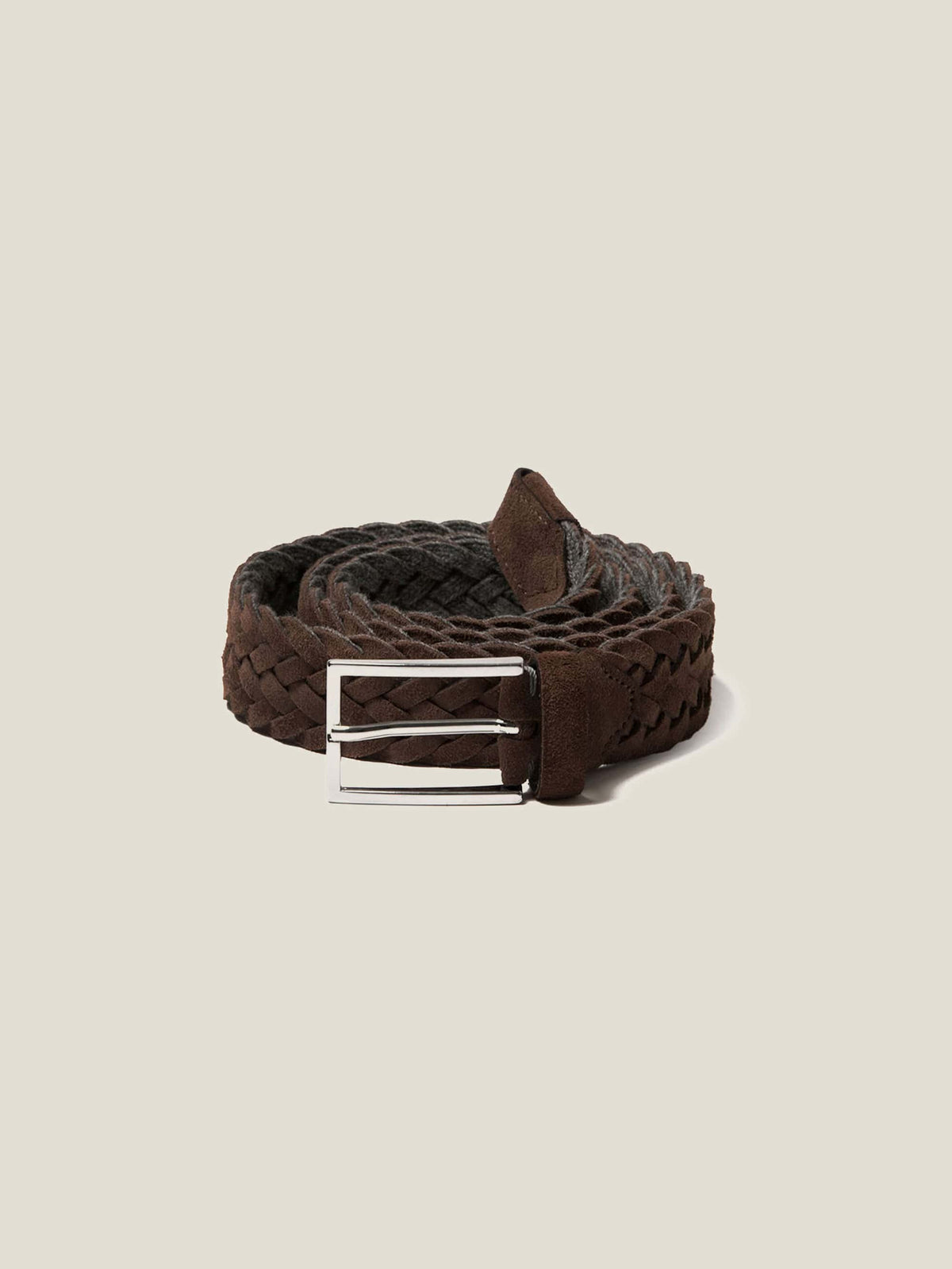 A coiled dark brown woven suede belt with a silver buckle, shown against a plain studio background.