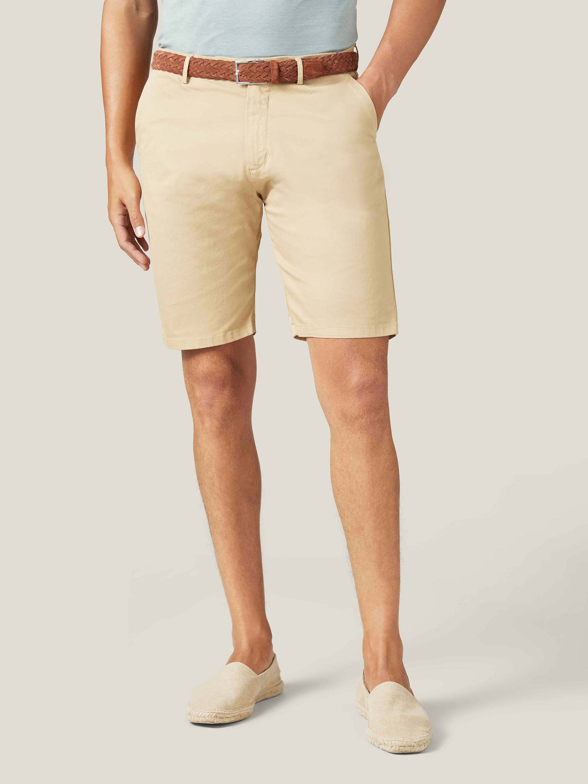 A front view of a model wearing the Luca Faloni light brown woven suede belt with beige shorts and a light blue T-shirt.