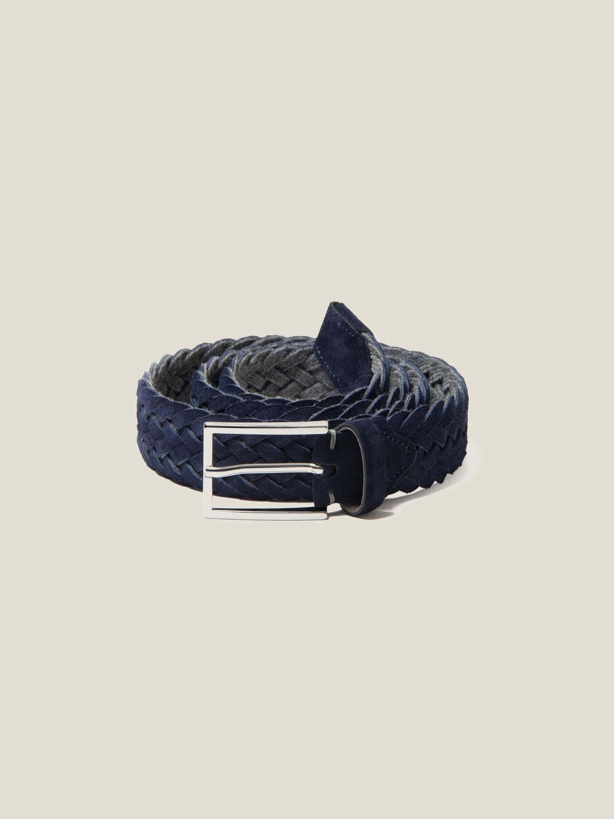 Studio shot of a coiled Luca Faloni navy blue woven suede belt with a silver buckle.