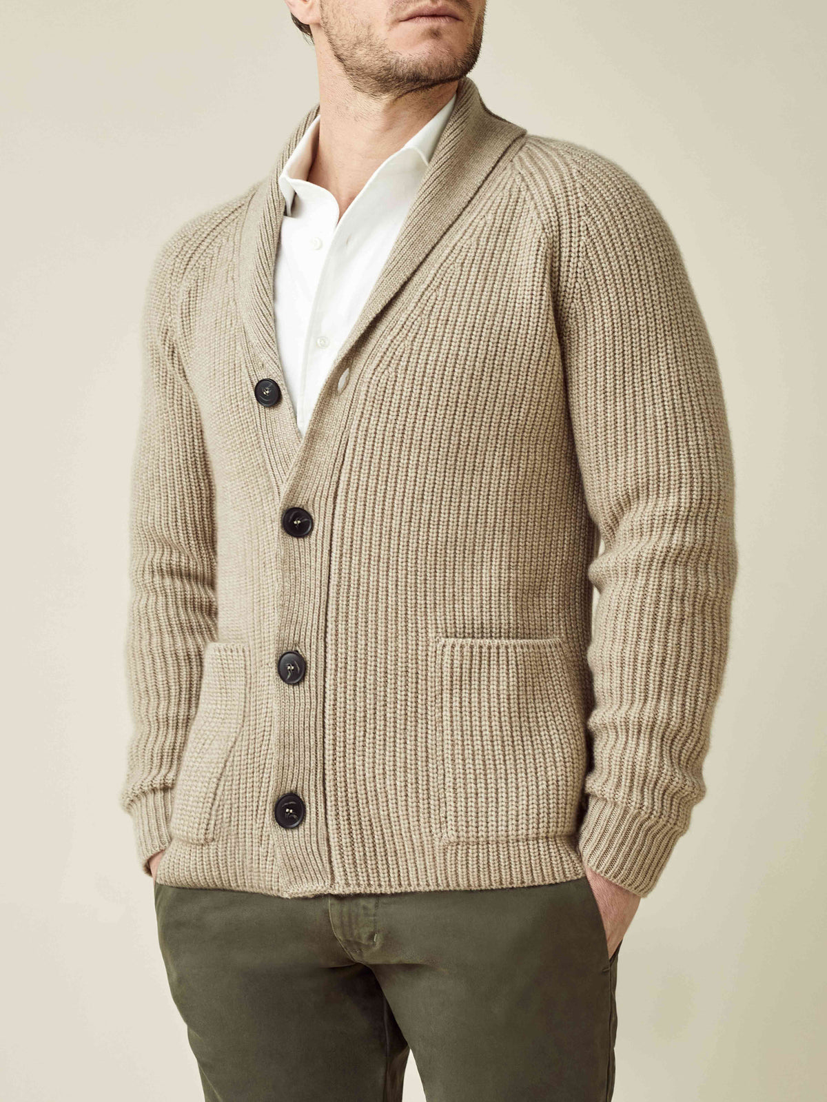 Front view of a man wearing the Chunky Knit Cardigan in Camel Beige, styled with a white shirt and dark green trousers.