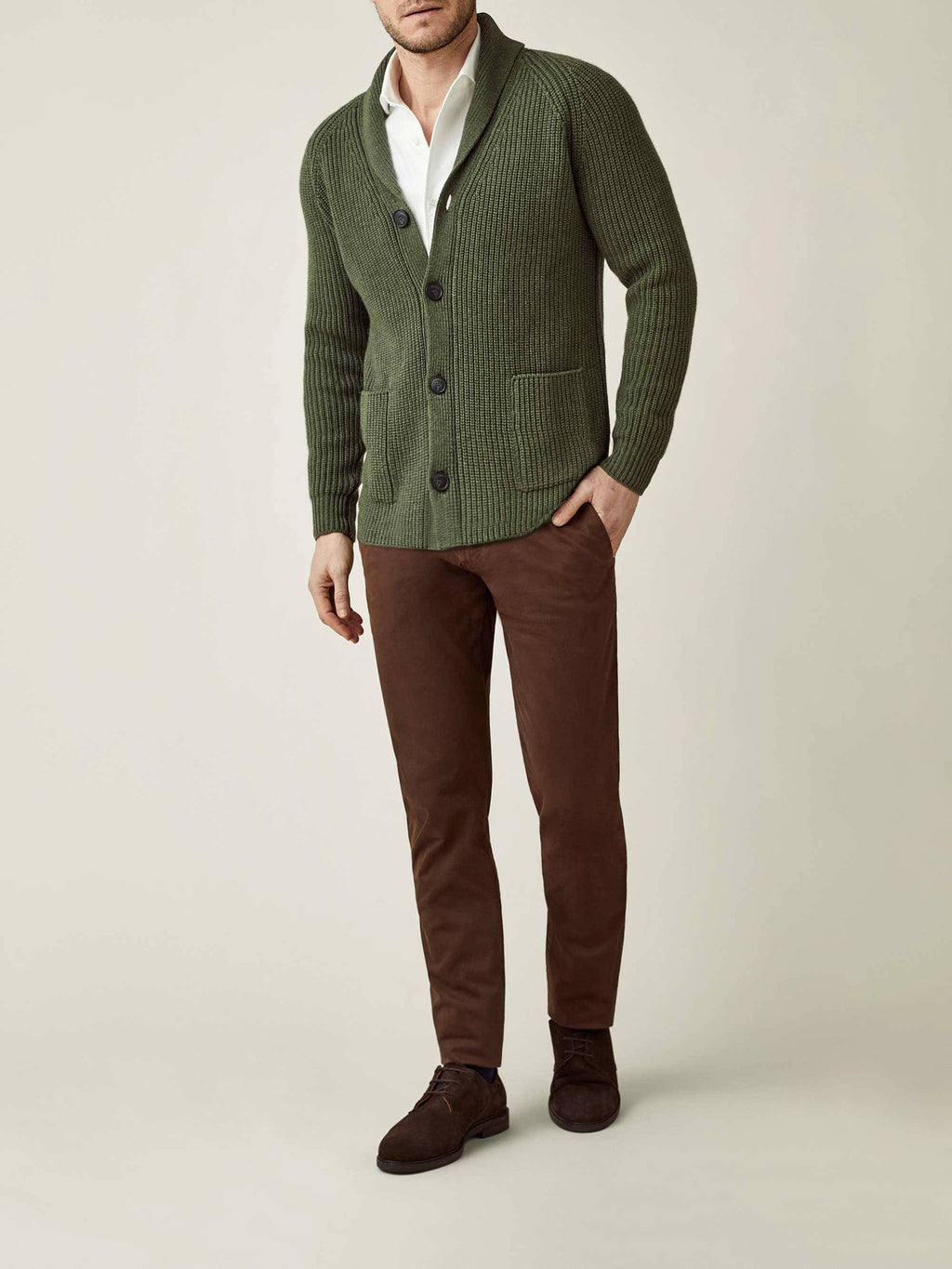 Model wears Luca Faloni's Chunky Knit Cardigan in Hunting Green, styled with a white shirt and brown trousers.
