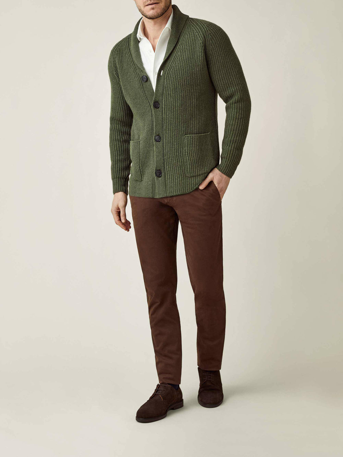 Model wears Luca Faloni's Chunky Knit Cardigan in Hunting Green, styled with a white shirt and brown trousers.
