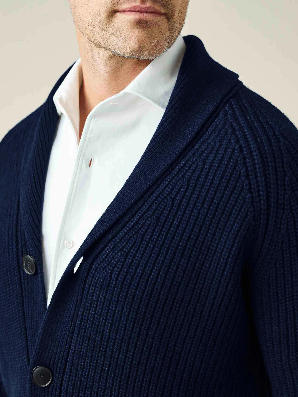 Close-up on the shawl collar and ribbed texture of the Midnight Blue Chunky Knit Cashmere Cardigan, worn by a model.