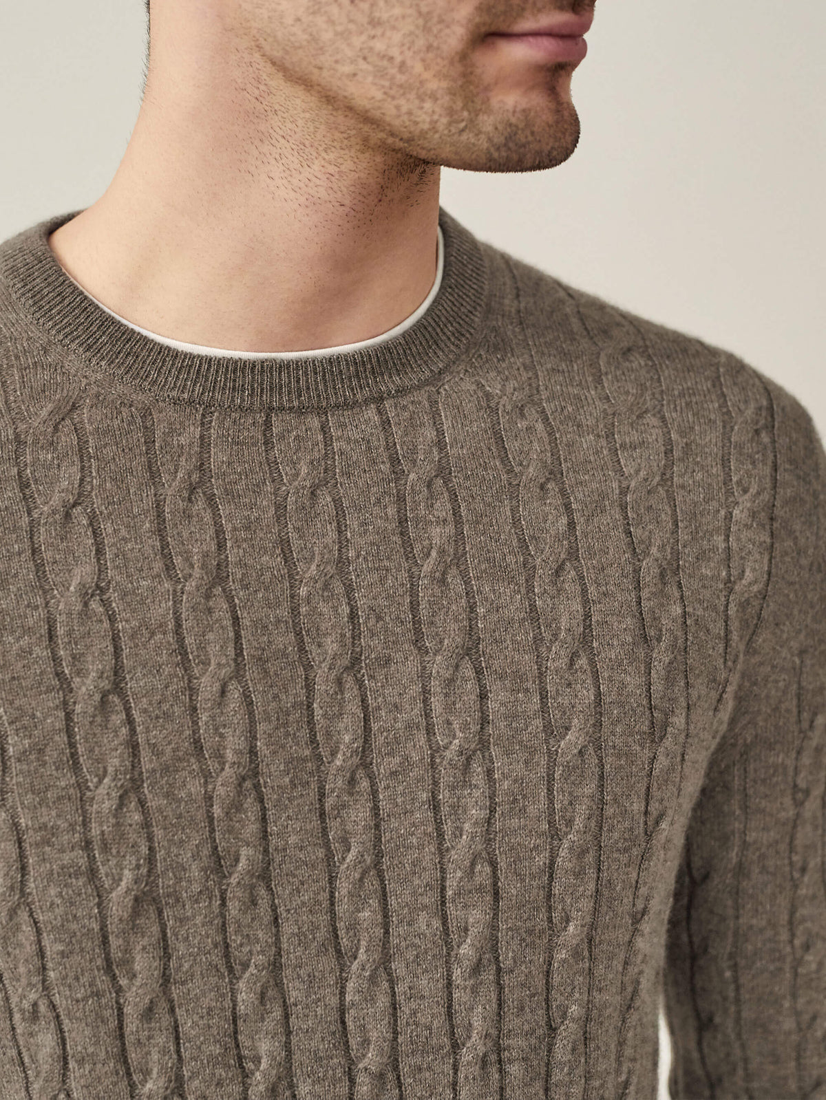 Close-up of a model wearing the Nocciola Brown Cashmere Cable Knit, showing the intricate texture and ribbed crew neckline.