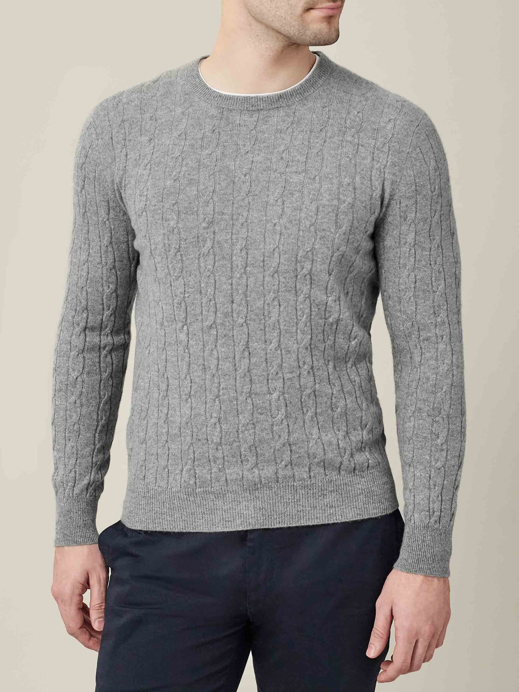 A man models the Dolomiti Grey Cashmere Cable Knit, showcasing its refined texture and classic crew neck design.