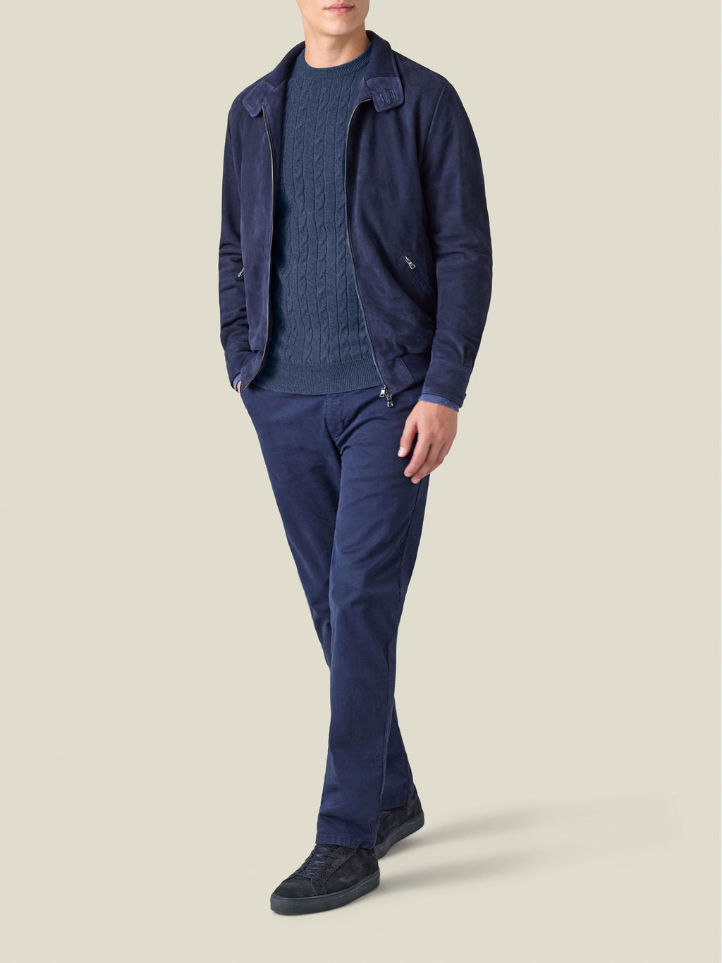 Model wears the Atlantic Blue Cashmere Cable Knit sweater, layered under a navy suede jacket and paired with navy trousers.