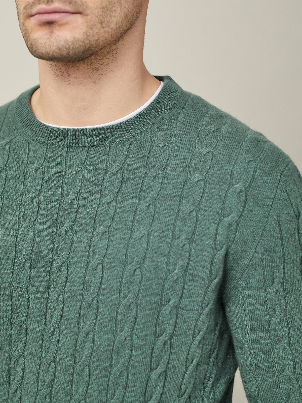 A close-up of a man wearing the Marine Green Cashmere Cable Knit, showing the intricate knit texture and crew neckline.