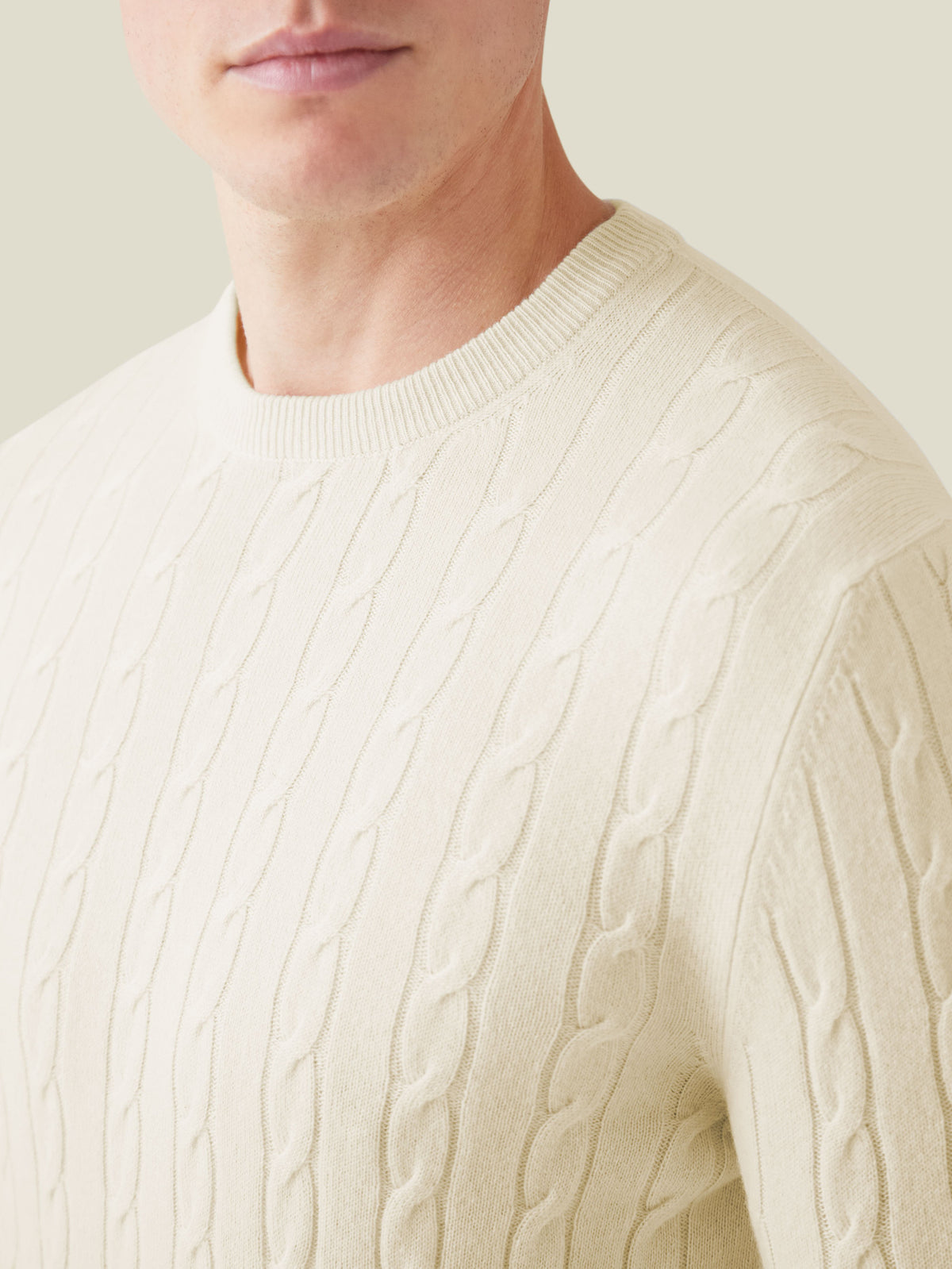 Luca Faloni ivory cashmere cable knit jumper shown on a model, highlighting the detailed knit pattern and classic crew neck.